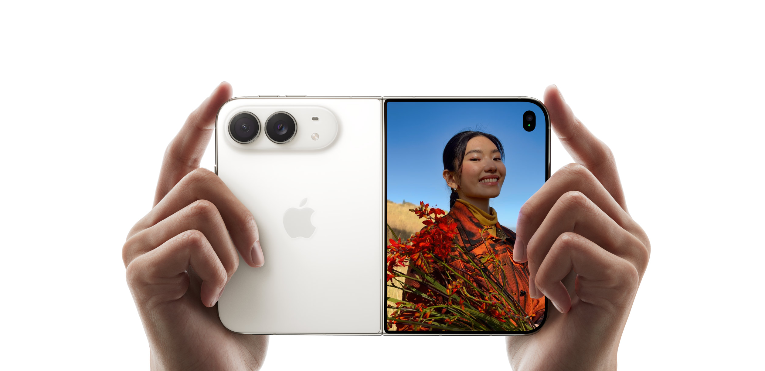 Two hands holding an open white iPhone Duo, with its two rear cameras on one half and a photo preview on the outside screen. Image: Apple
